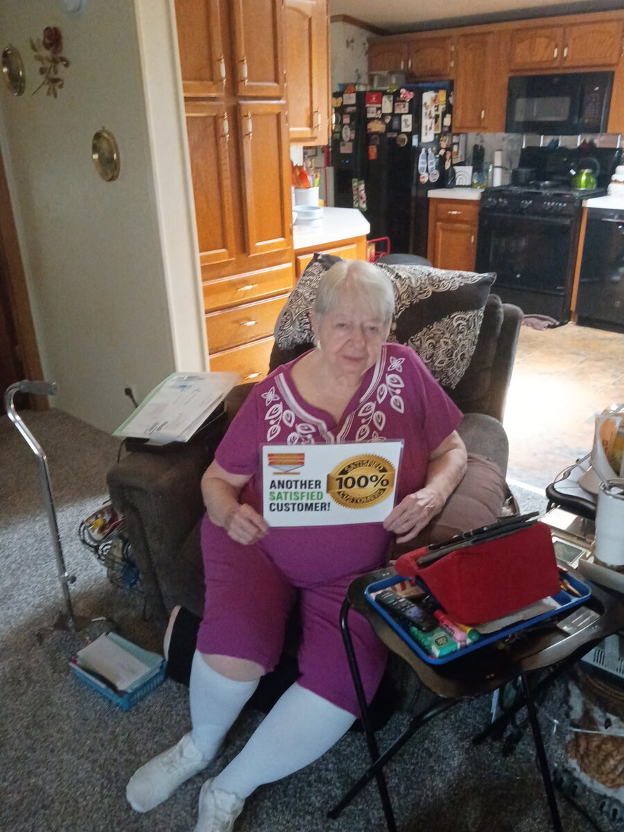 Deck Last customer holding a 100% satisfied customer sign