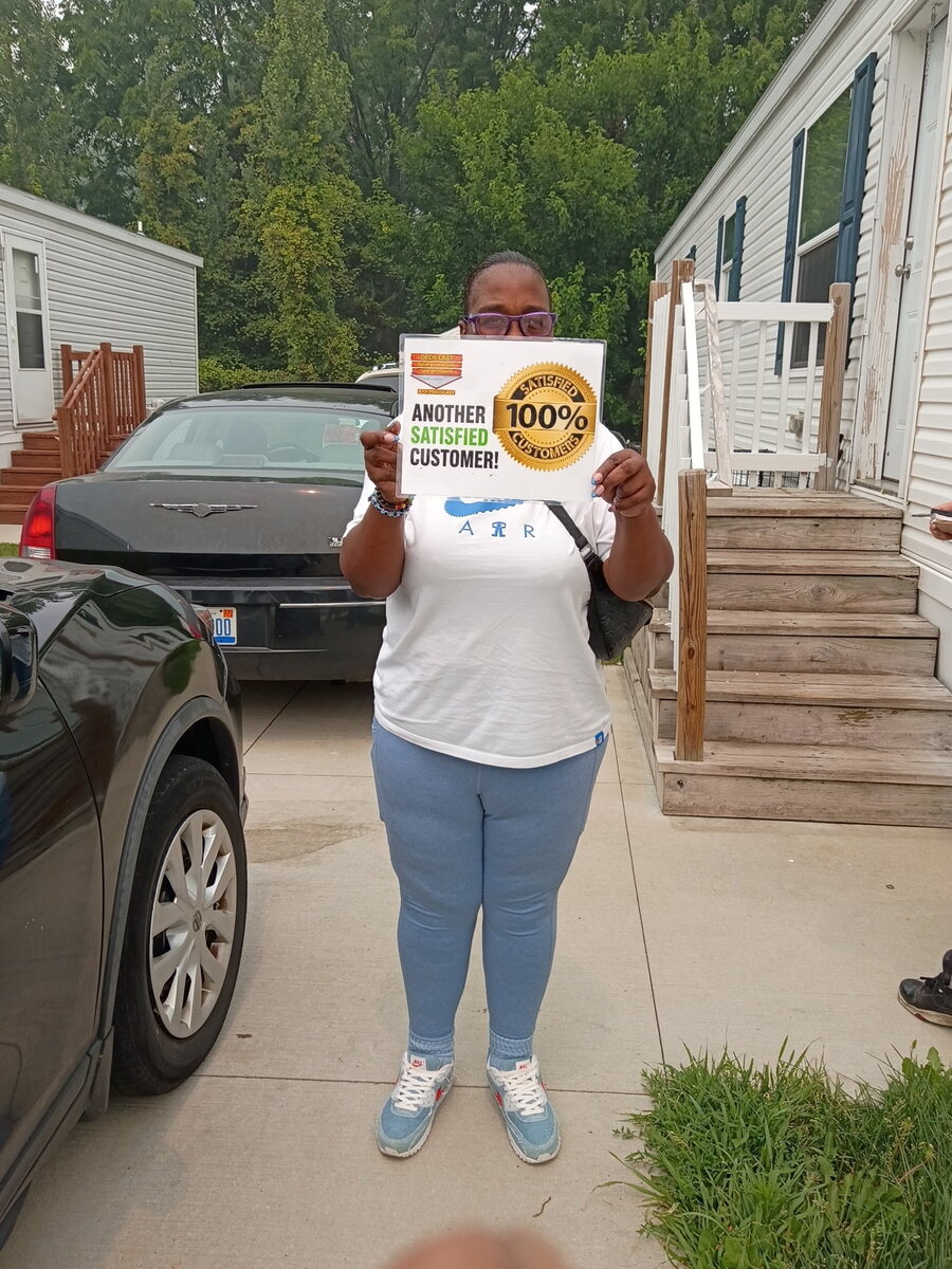Deck Last customer holding a 100% satisfied customer sign