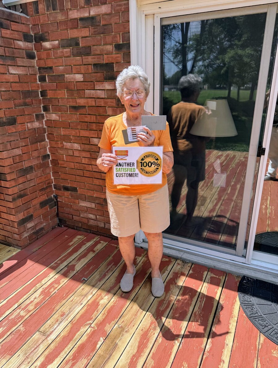 Smiling Deck Last customer standing on her deck with a 100% satisfied customer sign